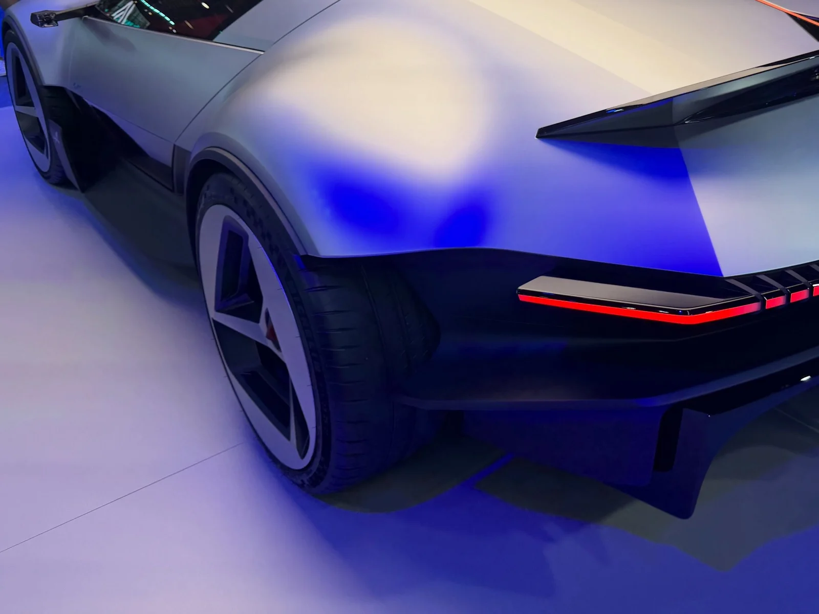 Hanche arrière et feu rouge filiforme de l'Alpine A310 Vision, concept gris sous éclairage bleu à Paris, en 2026