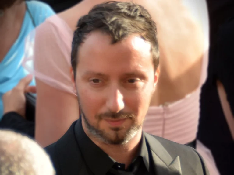 Portrait d'Anthony Vaccarello, directeur artistique de Saint Laurent, en costume noir, regard baissé, en 2017
