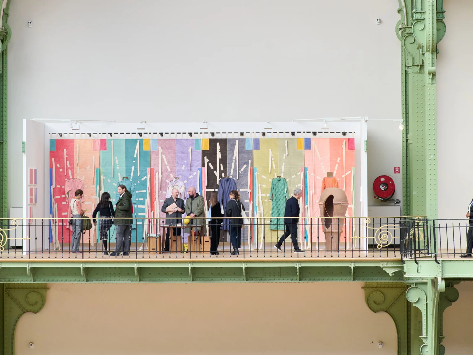 Visiteurs devant une installation textile colorée sur le balcon du Grand Palais lors d'Art Basel Paris 2025
