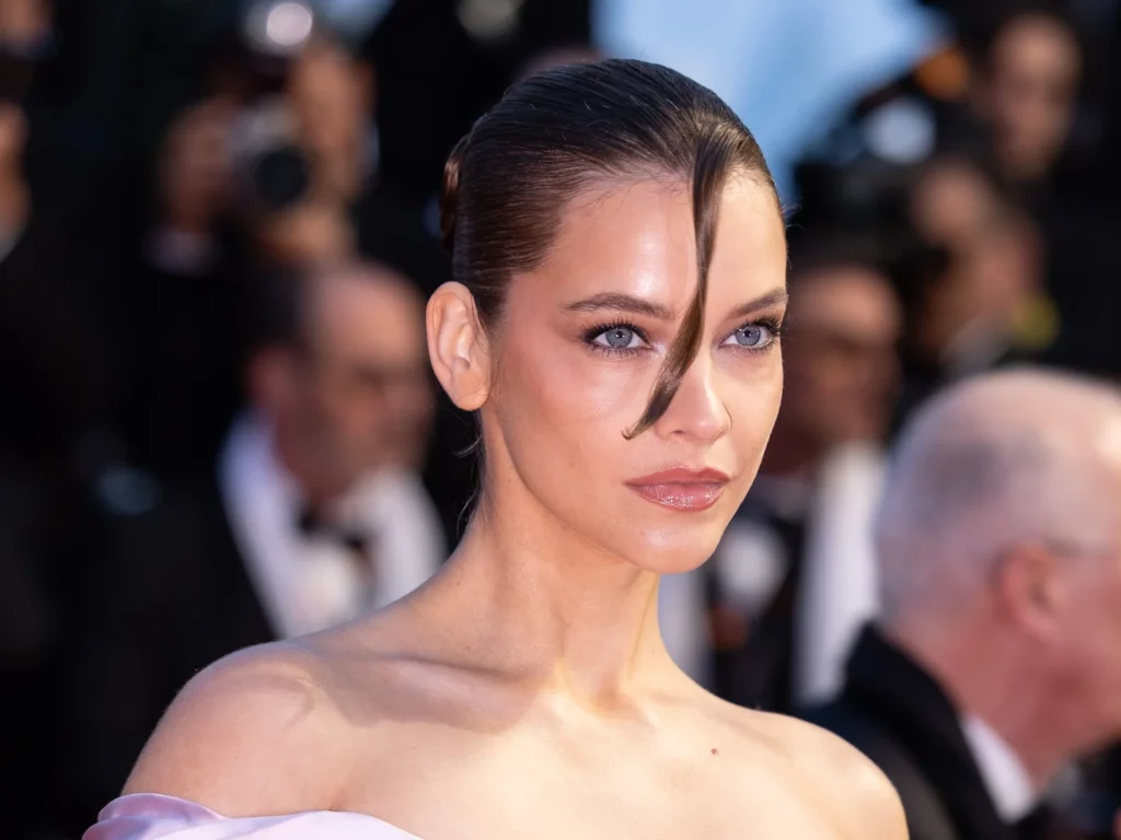 Portrait de Barbara Palvin, chignon lissé et épaules nues, sur les marches du Festival de Cannes 2025