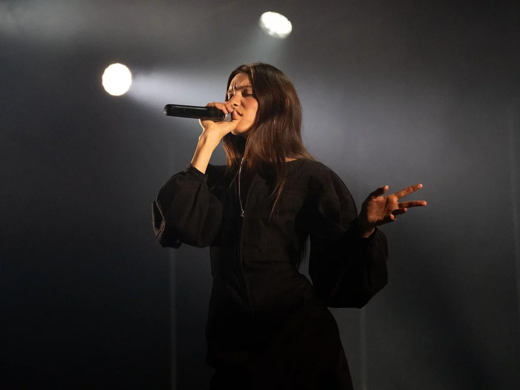 Charlotte Cardin chante les yeux fermés, micro en main, dans la brume des projecteurs au Montreux Jazz Festival 2026