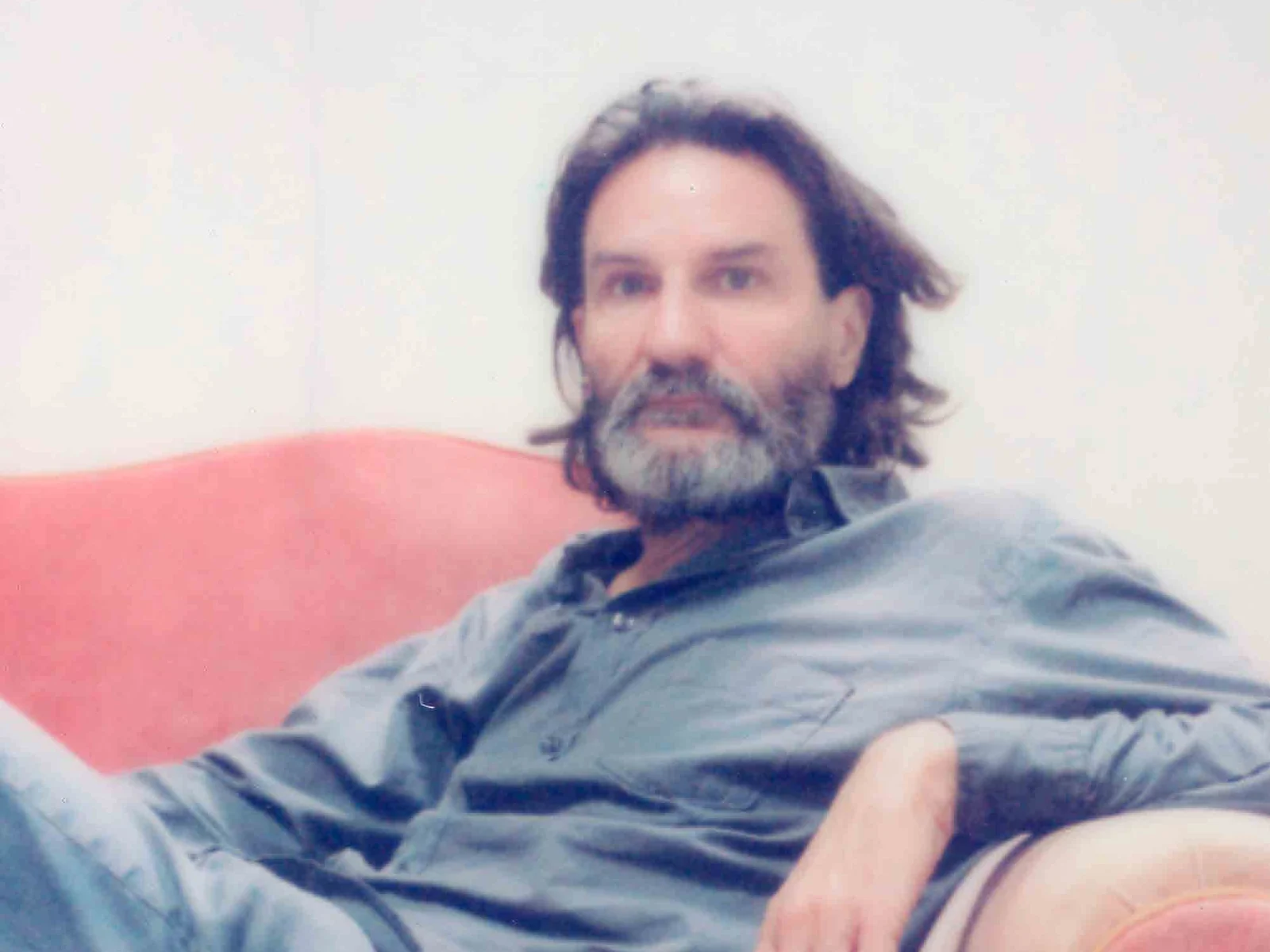 Frédéric Beigbeder en chemise en jean, assis dans un fauteuil rose, portrait réalisé pour le grand entretien de LUI