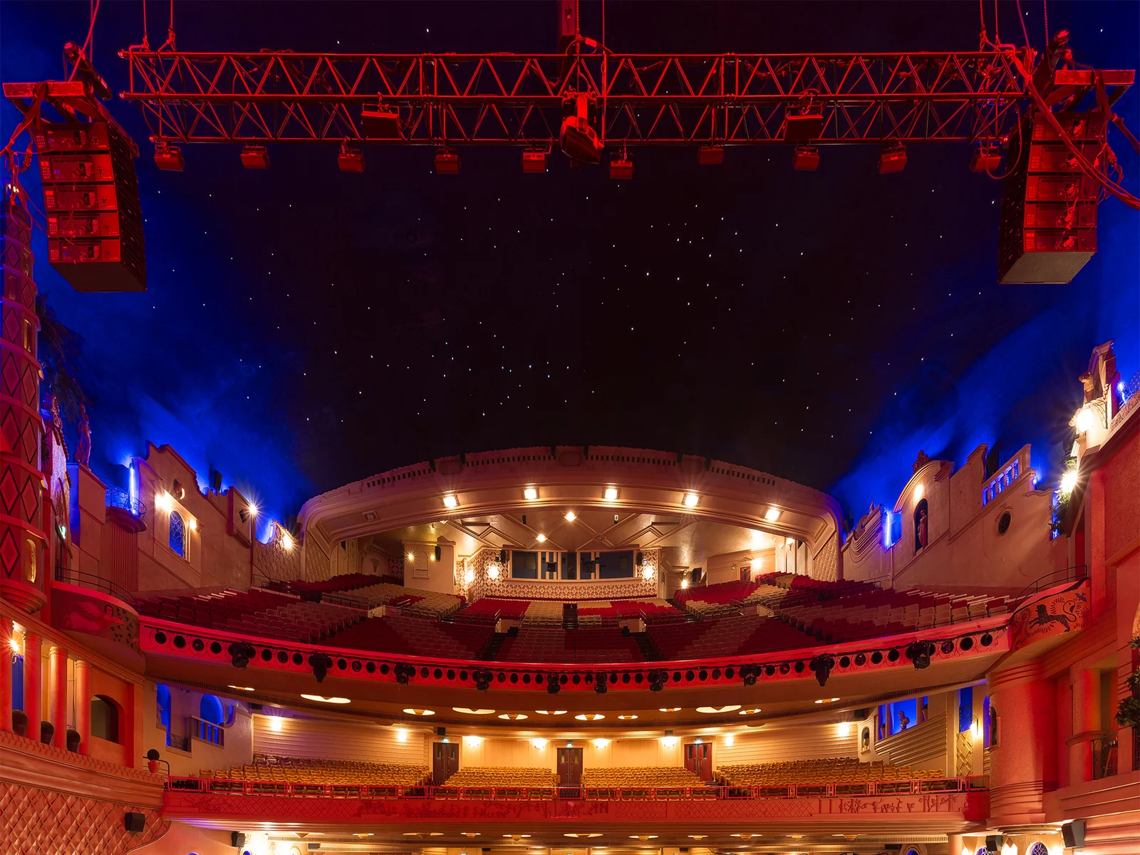 La Grande Salle du Grand Rex à Paris, balcons à l'italienne et plafond étoilé baignés de lumière rouge et bleue
