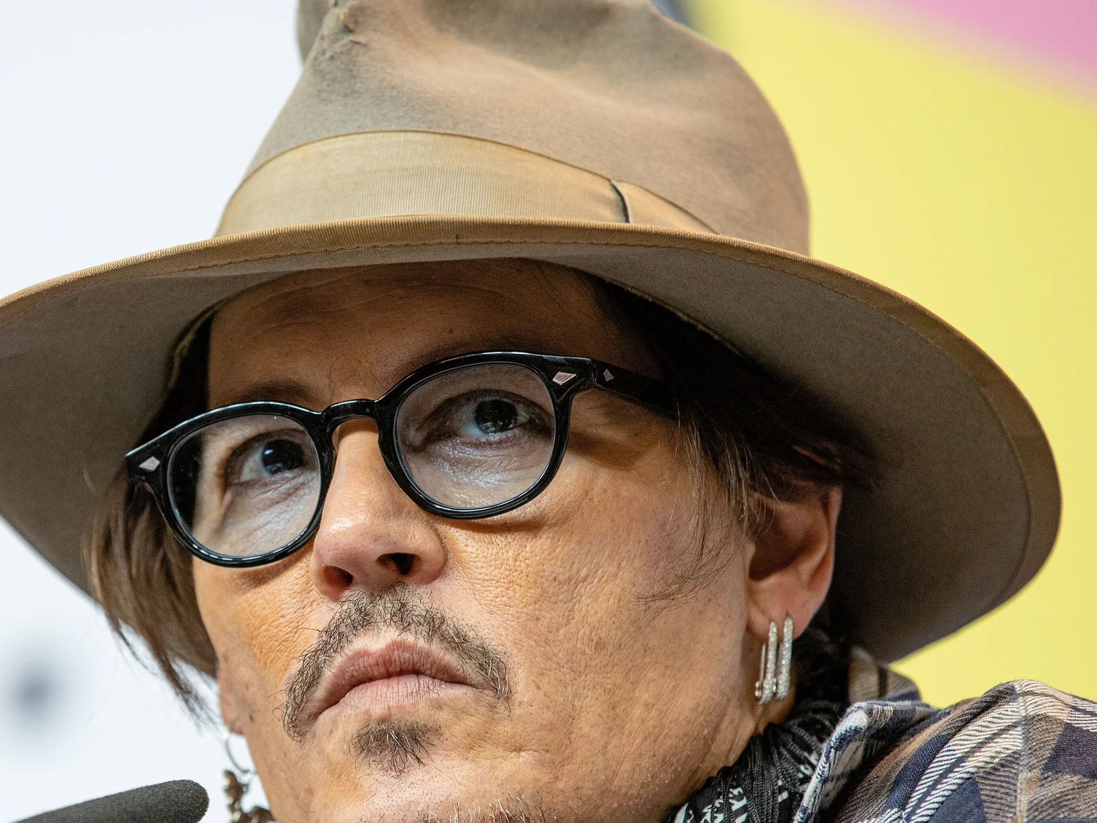 Gros plan de l'acteur Johnny Depp, chapeau et lunettes rondes, lors d'une conférence de presse à la Berlinale 2020