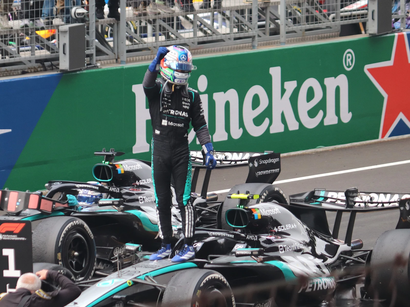 Kimi Antonelli casqué, poing levé, debout sur sa Mercedes après le Grand Prix de Chine 2026 à Shanghai