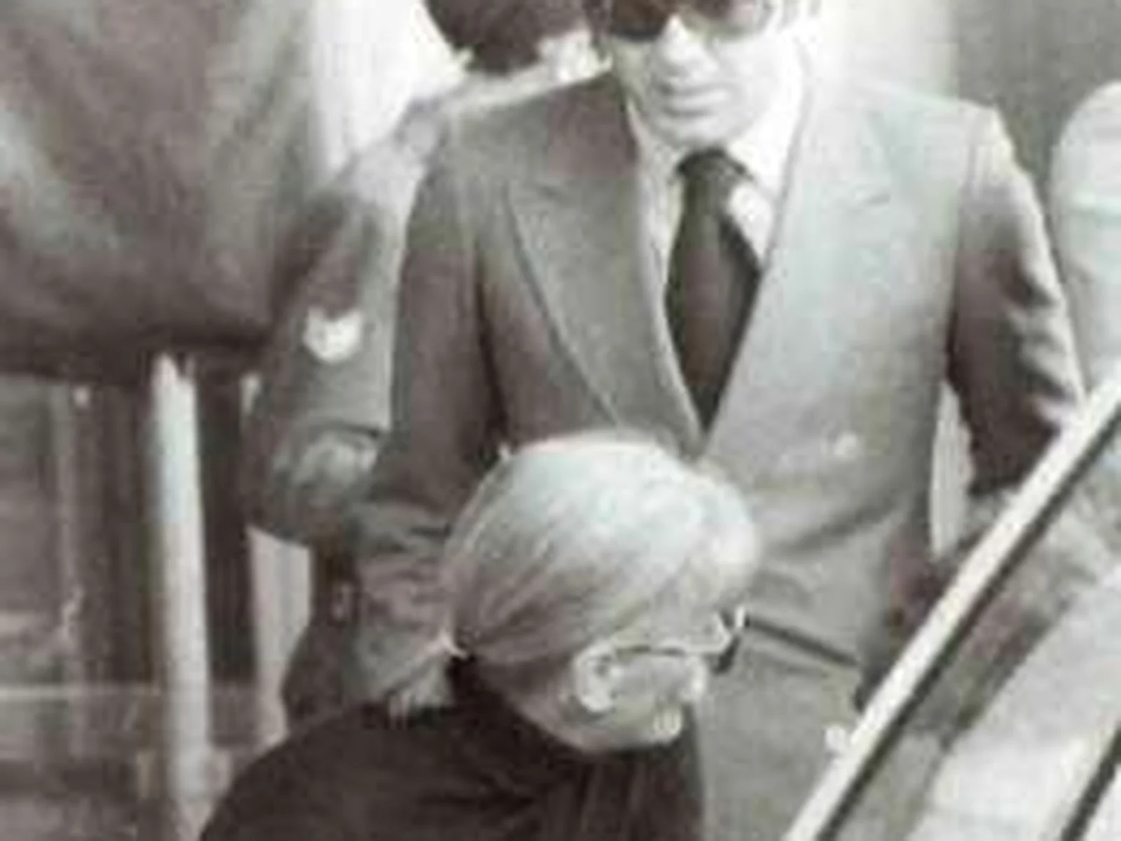 Massimo Gargia en costume et lunettes noires aux côtés de Greta Garbo, photographie d'archive en noir et blanc