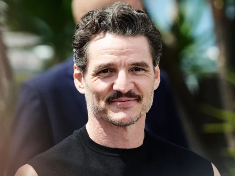 Portrait de l'acteur Pedro Pascal souriant, cheveux bruns et moustache, au photocall du Festival de Cannes 2025