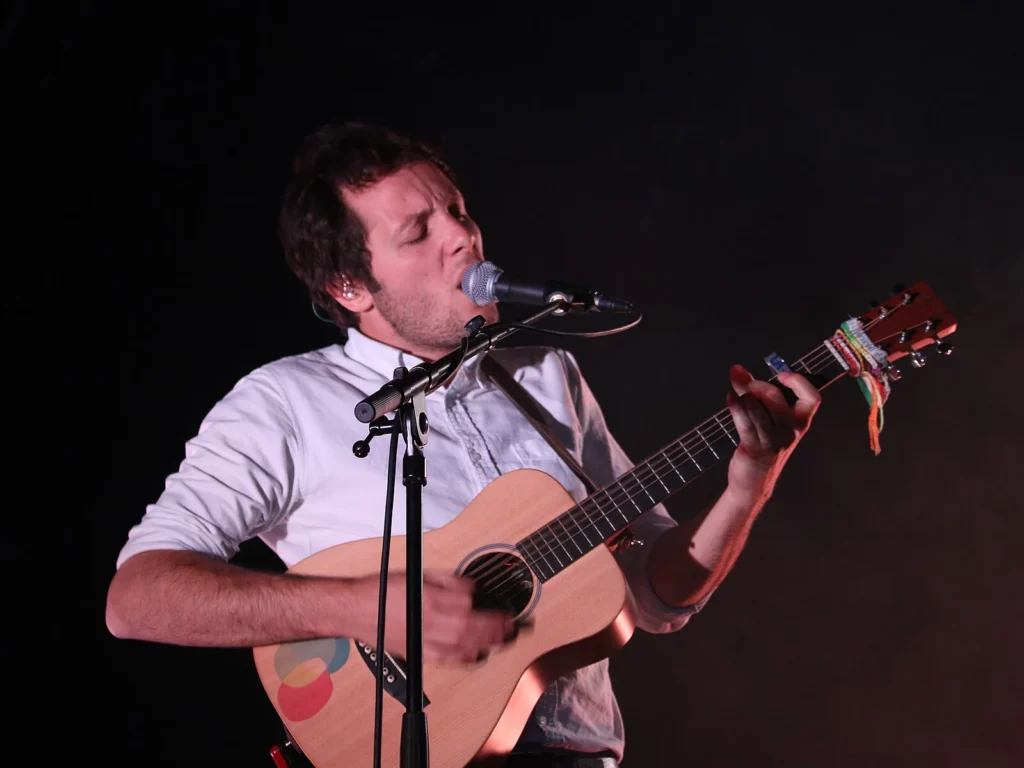 Le chanteur Vianney en chemise blanche, guitare acoustique et micro, sur scène au Paléo Festival de Nyon en juillet 2016